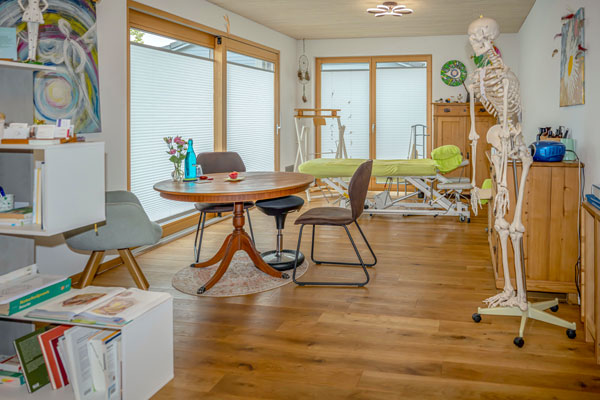 Heller Behandlungsraum mit Tisch, Regal und Skelettmodell Heller Behandlungsraum mit Tisch, Regal und Skelettmodell