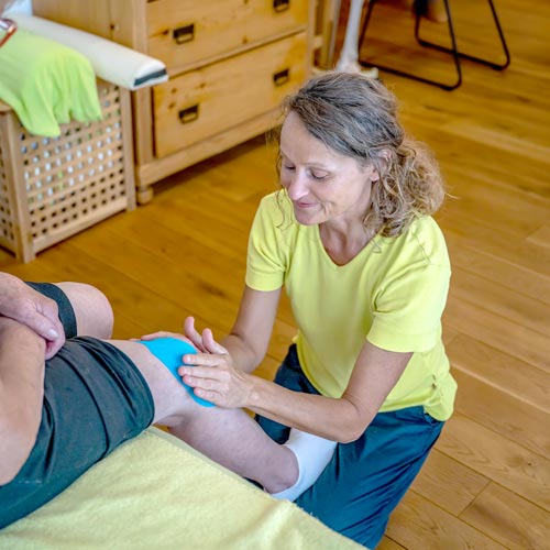 Olga Gaile legt ein Kinesio-Tape am Knie an