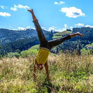 Olga Gaile schlägt ein Rad auf einer Bergwiese